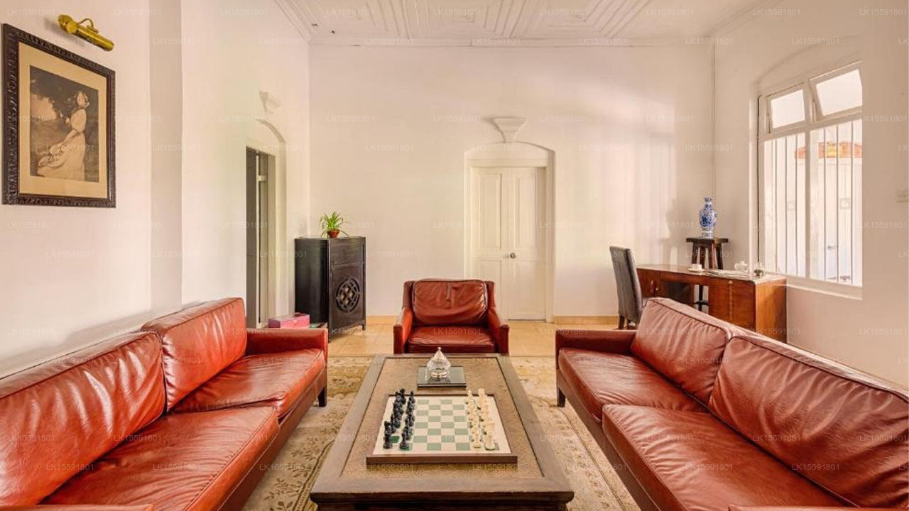Living room with red leather sofas and a coffee table with a chessboard.