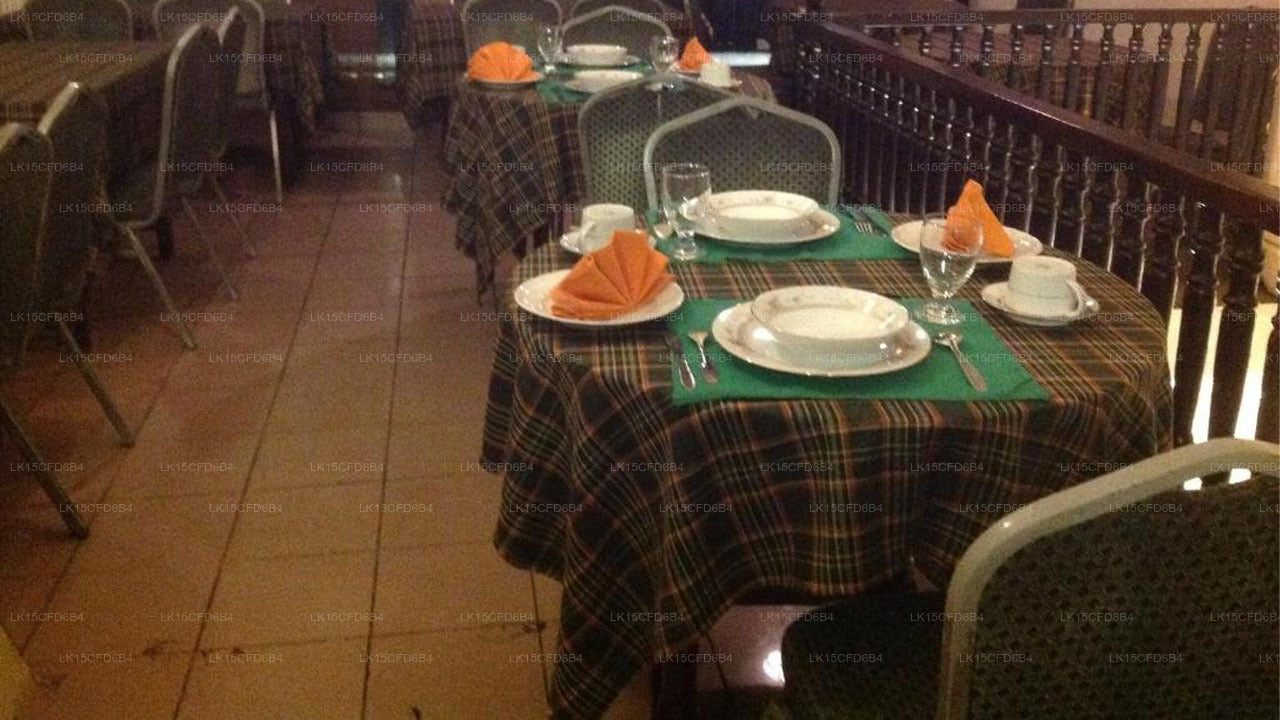 Dining area with tables set for a meal, plaid tablecloths, and chairs.